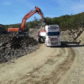 Gravemaskin laster opp lastebil