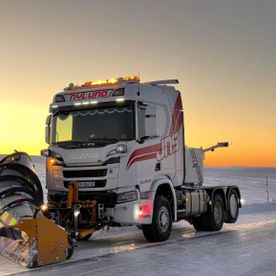 Hvit lastebil med snøplog