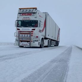 Hvit trailer på snødekt vei