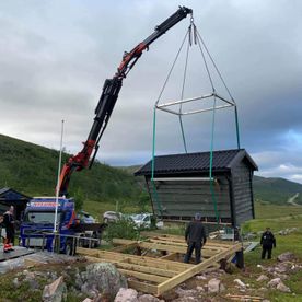 Flytter hytte med kranbil