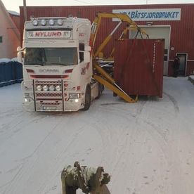 Hvit lastebil utenfor lager